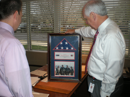 Community Involvement: President Bill Sautter and COO Jim Pizzi admire the framed flag